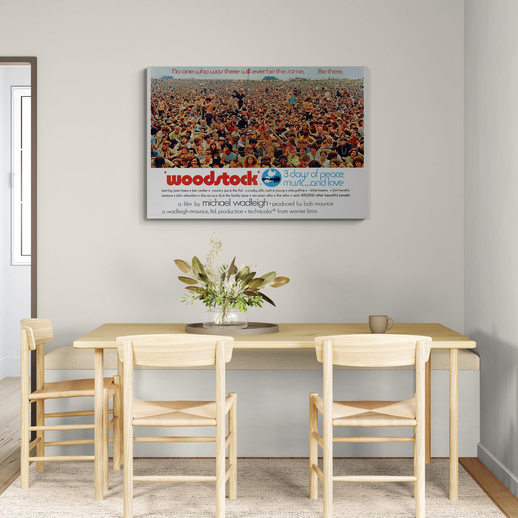Dining room with a 'Woodstock' movie poster on the wall above a table and chairs.
