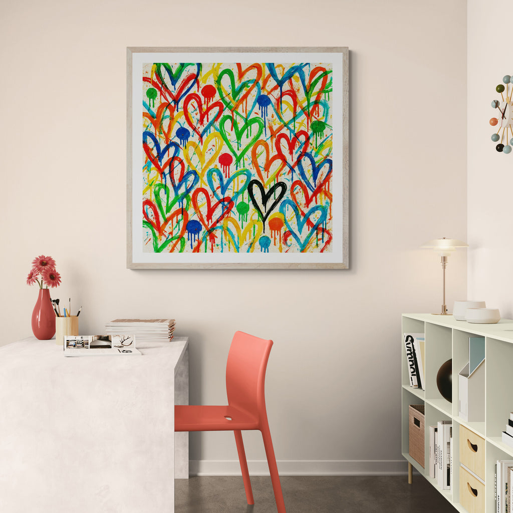 Colorful heart-shaped abstract art piece on a wall above a desk with a red chair.