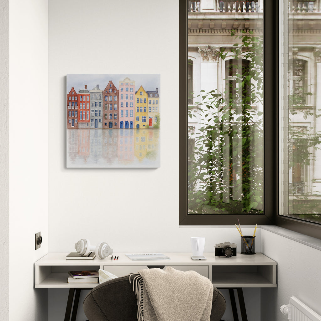 Modern home office with a desk, chair, and wall art of colorful buildings.