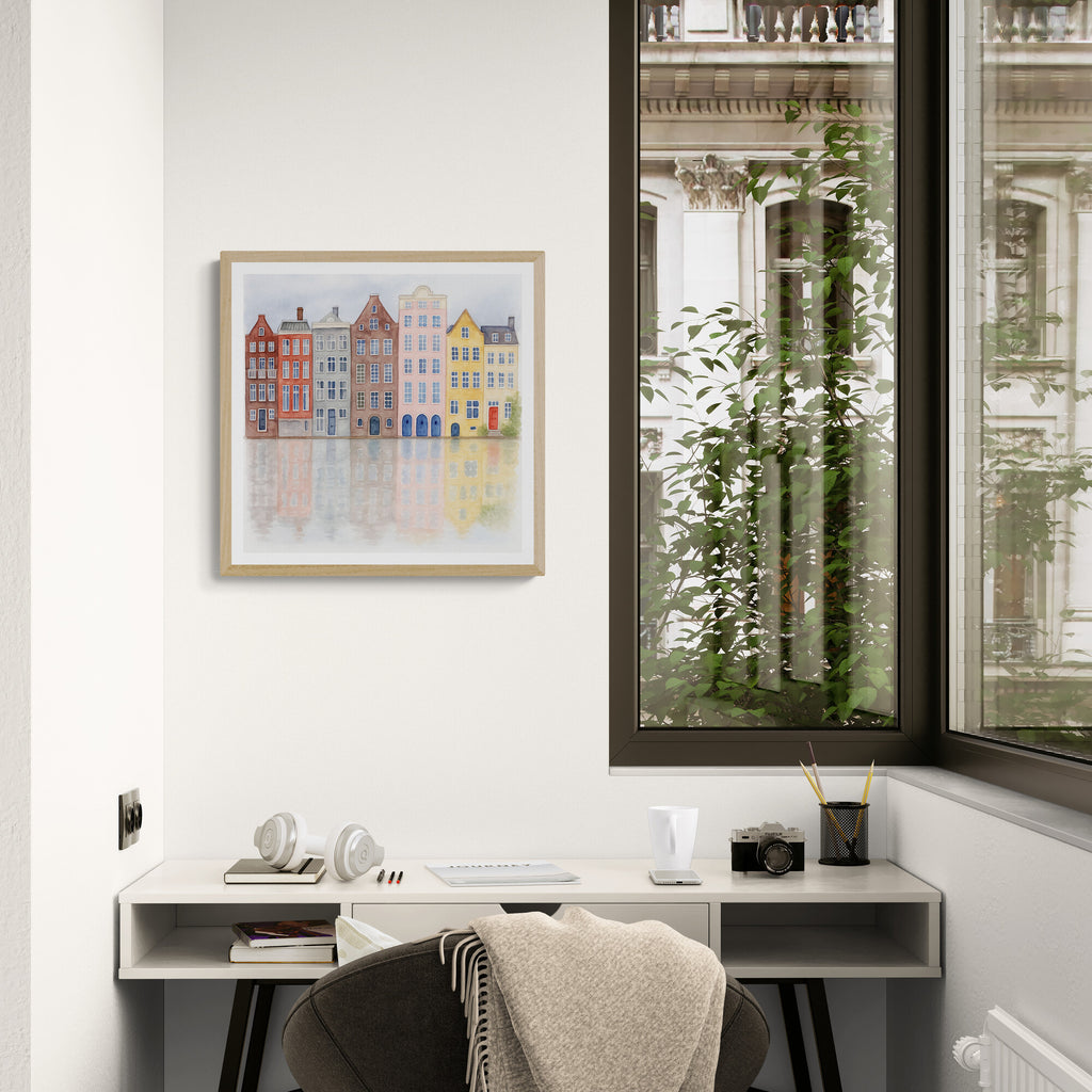 Home office with a desk, chair, and framed artwork on a white wall.